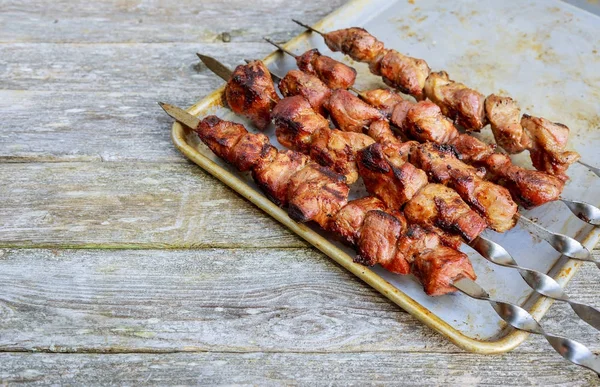 Shish kebab en pinchos con cebolla. En la mesa de madera . —  Fotos de Stock
