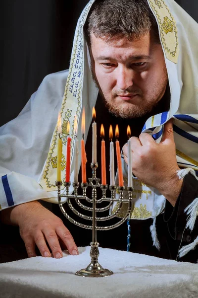 Jewish candle lights male hand lighting candles in menorah