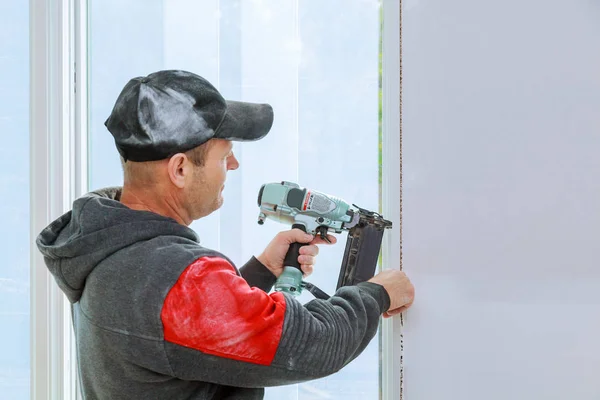 Carpintero con pistola de clavos brad ventana de ajuste completo — Foto de Stock