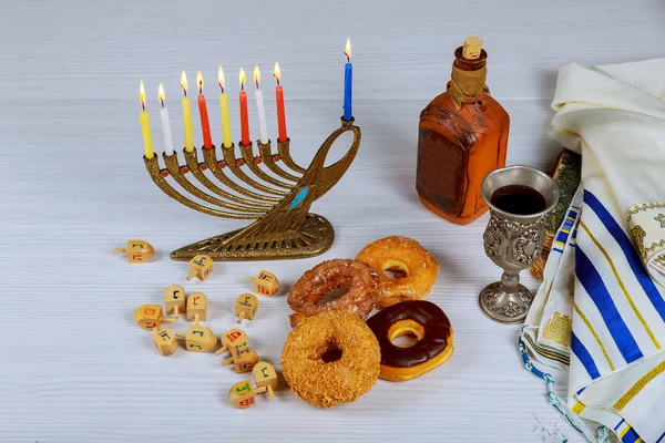 Jüdische Feiertagshannukah-Symbole - Menora, Donuts, Schokoladenmünzen und hölzerne Dreidel. — Stockfoto