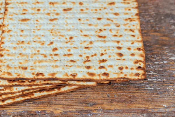 Kosher judeu matzah closeup em papel em uma mesa de madeira. vista horizontal — Fotografia de Stock