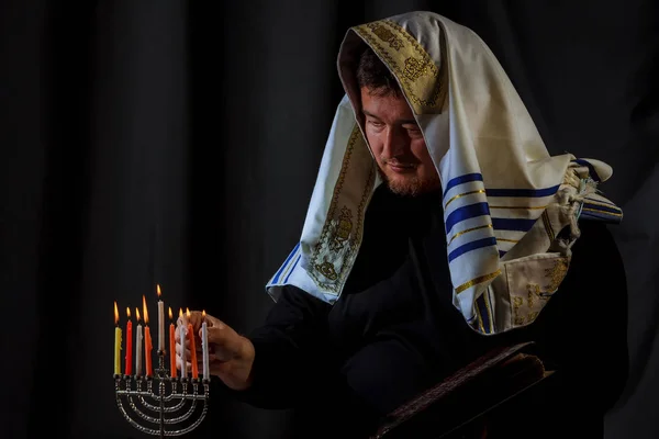 Hanukkah, una celebración judía. Velas ardiendo en la menorá, el hombre en el fondo . — Foto de Stock