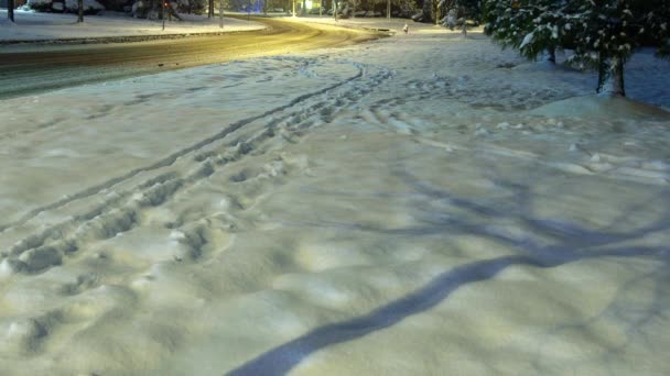 雪と冬の雪の夜の危険な道路条件によって秘密地区道路覆われ、郡道を照らされた夜 — ストック動画