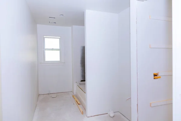 Nuevo interior de baño en construcción con paneles de yeso y parches — Foto de Stock