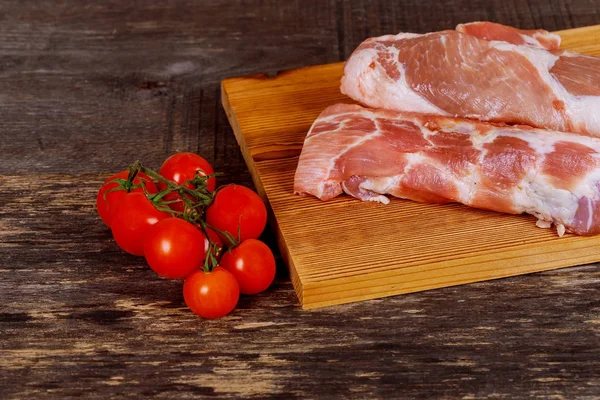 Domuz eti biftek domates ile ahşap arka plan üzerinde