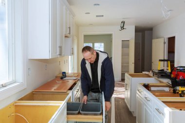 Alt kümeleri bir beyaz mutfak dolapları yükleme bir tornavida ile dolap