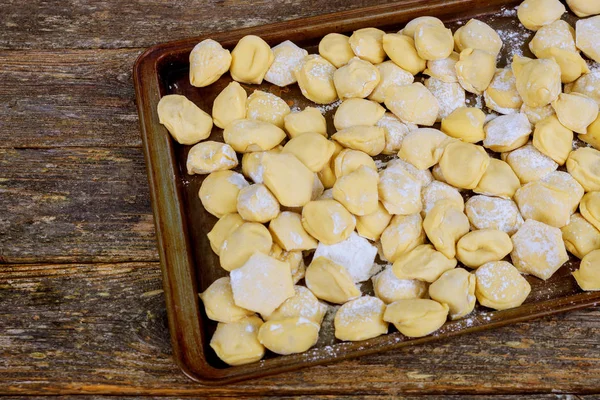 Processen att göra hemmagjord pelmeni dumplings på träskiva - traditionella ukrainska rätter. — Stockfoto