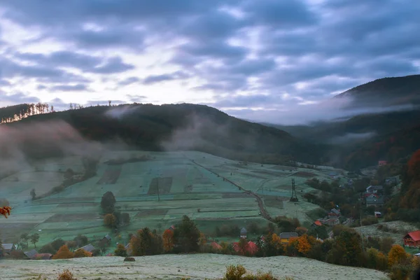 Herbstlandschaft. Dorf am Hang. Wald im Nebel auf Bergen bei Vollmondlicht — Stockfoto