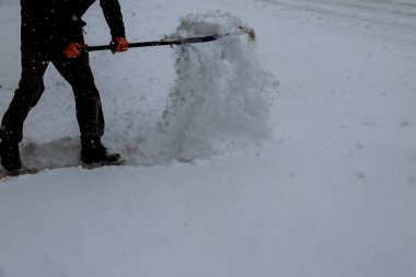 Adam kar küreği ile kaldırımlar kışın temizler. Kış zamanı. Adam bir kürek ile kar kaldırma