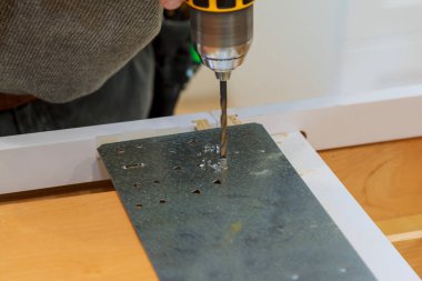 Sakallı adam elinde tornavidayla kendi kendine metal profil, seçici odak ana matkap bir metal yaprak diş mahvoldu