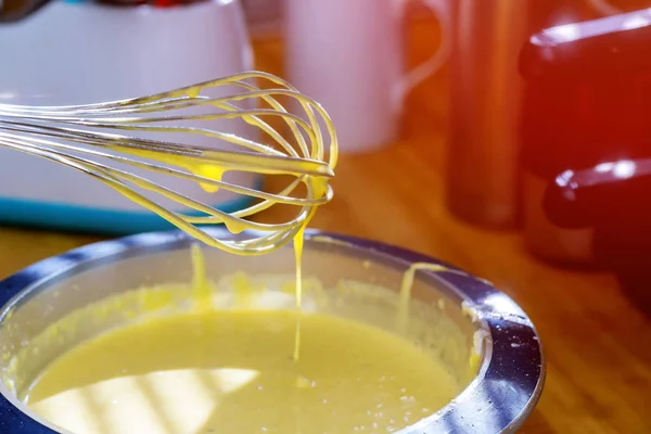 Mixing egg, flour and sugar cream in bowl with motor mixer. Kneaded dough for baking a cake