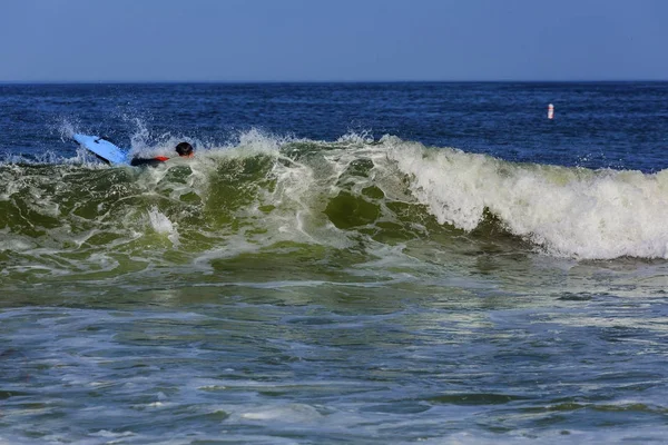 日の時間に大きな海の波に乗っサーファーが海で大きな波を泳ぐサーフィン — ストック写真