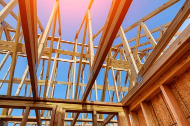 Gables çatı Stick Close-Up eve yeni inşa ahşap truss, deftere naklet ve kiriş çerçeve ile çatı inşaat ve mavi gökyüzü altında inşa edilmiş. Ahşap çerçeve ev, gayrimenkul arka plan