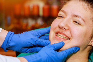 Diş ameliyatı veya diş teli tedavisi diş hekimi ve ortodontist kavramı yapılır. Beyaz dişlerini gösteren kadın gülümseme