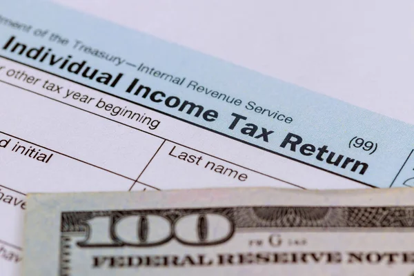 Tiempo de impuestos Primer plano de la declaración de impuestos de EE.UU. 1040 con 100 facturas —  Fotos de Stock