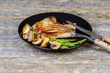 Mantar ve kuşkonmaz ile tavada ızgara biftek. bir mutfak, lezzetli, baharatlı, sulu et kopya alanı closeup ile pişirme.