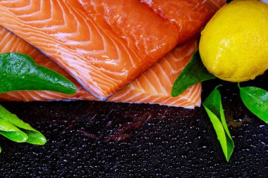 Çiğ somon balık fileto siyah arka plan ve limon