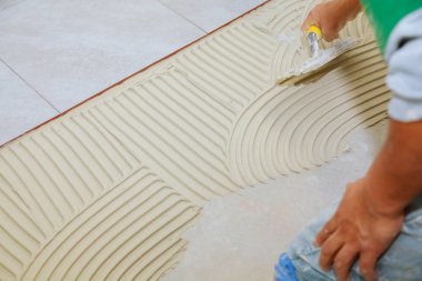 Islak harç fayans banyoda yerde uygulamadan önce yayılıyor. yapıştırıcı koyar