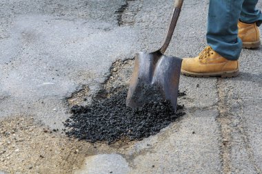 Yol yapımı. Yeni asfalt beton, beton kaldırıma ve turuncu Emanet