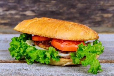 Patates kızartması ile iştah açıcı hamburger, ahşap kesme tahtası üzerinde bira.