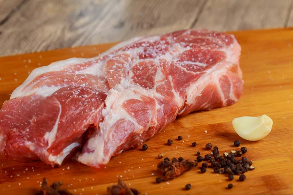 Taze ve çiğ bonfile madalyonlar biftek rustik ahşap masa üzerinde sebze ve otlar ile