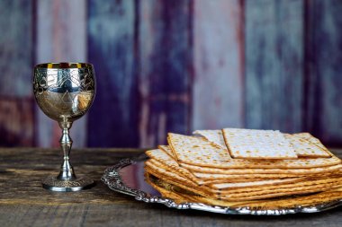 Fısıh cam şarap ve matzah portre. Arkadan aydınlatmalı matzah doku içinde geçmiş bulanık.