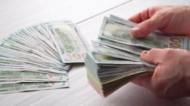 Erkek el bize güveniyor Doları banknot ön masada bir dizüstü bilgisayar adam muhasebeci para faturaları ile yakın çekim