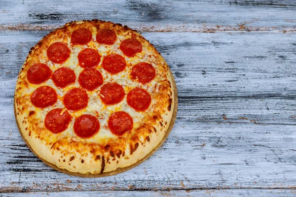 Pizza en deux avec poulet et champignons et légumes verts, sur l'autre - avec jambon et sauce. Sur fond de bois rustique aux légumes frais . — Photo