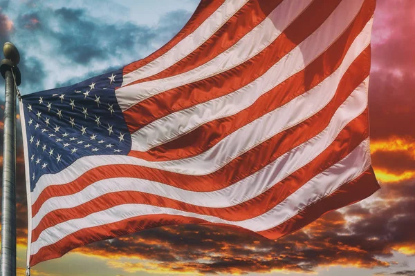 American flag flying, flag USA over beautiful Sunset sunrise with clouds, in pink and purple shades pink sky sunrise clouds — Stock Photo, Image