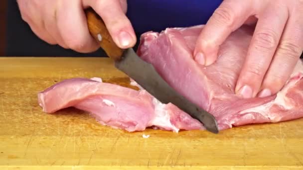 Pessoas Mãos utting pedaço de carne crua na superfície de madeira vintage. Chef Man segurando faca com as mãos e corte. Corte de carne em uma placa de cozinha de madeira — Vídeo de Stock