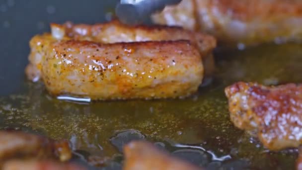 Mescolando in pezzi di una costoletta di maiale fritta su padella per friggere — Video Stock