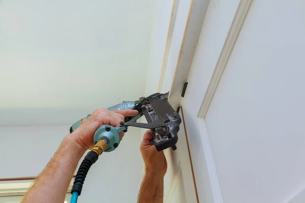 Hágalo usted mismo propietario de casa reparación de moldeo de marco de la puerta con pistola de clavos , — Foto de Stock
