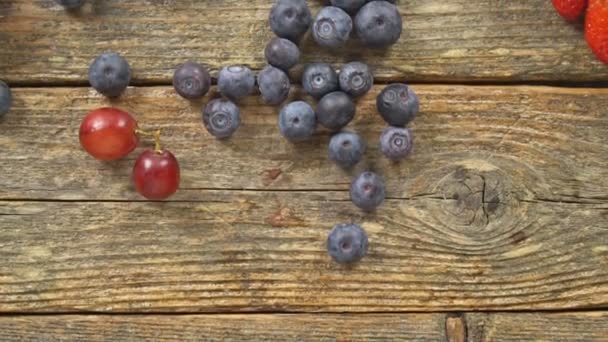 Blueberries Grape Strawberries on a wooden background SLOW MOTION hd video — Stock Video