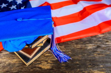 Kitaplar ile Amerikan bayrağı arka plan mavi mezuniyet şapka