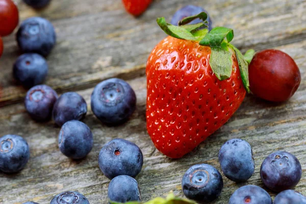 Frutas de verano en una mesa de madera. Arándanos Uvas Fresas — Foto de Stock