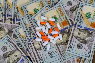 Avuç Amerikan Doları faturaları tıp sektöründe kar kavramı üzerinde dökülen hap