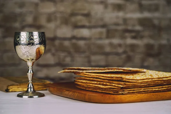 Červené víno košer s bílou deskou matzah nebo matza a Pesach Hagada na vinobraní dřevěné pozadí prezentováno jako vypití jídlo s kopií prostor. — Stock fotografie