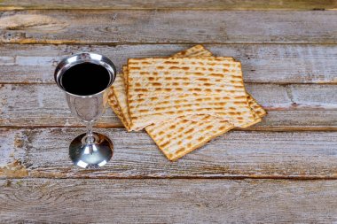 Fısıh cam şarap ve matzah portre. Arkadan aydınlatmalı matzah doku içinde geçmiş bulanık.