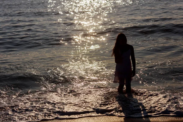 Heureuse petite fille courir le long de la côte de la mer du lever du soleil derrière — Photo