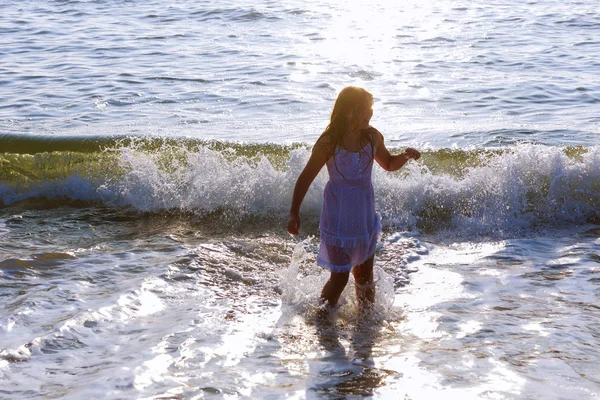 Menina feliz bonito correndo ao longo da praia em saltar sobre as ondas. Belo dia ensolarado de verão, mar azul, paisagem pitoresca . — Fotografia de Stock