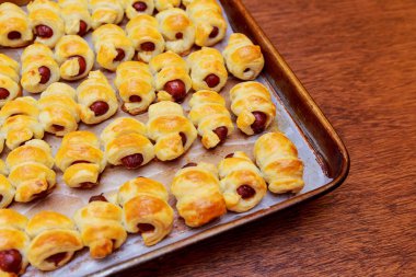 Hamur içinde ev yapımı. Sıcak sac pişirme üzerinde hamur sosis sarılmış