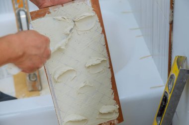 Çimento harcı ile fayans iş üzerinde inşaat mason adam eller