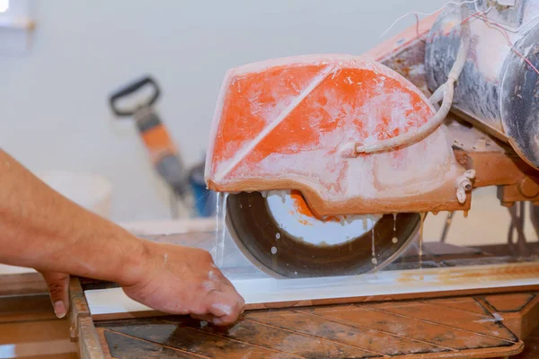 Découpe manuelle de carreaux de céramique sur une machine spéciale pour la découpe de carreaux . — Photo