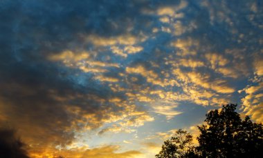 Güzel günbatımı gökyüzü, parlak mavi, turuncu ve sarı renkler göksel yatay, güneşin bulutların altında
