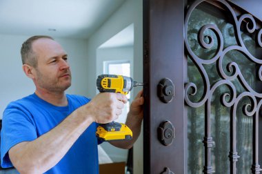 Vidalar, yakın çekim tutmak için bir matkap tornavida kullanarak kapı yaprak bir kilit ile iç montajı.