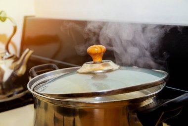 Tavuk, sebzeli tavuk çorbasında gaz sobasında pişirilir.