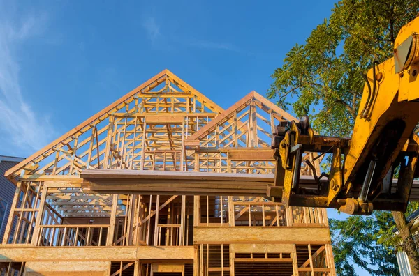 Heavy boom truck machinery is used to add the roof trusses to a timber frame house extension — Stock Photo, Image