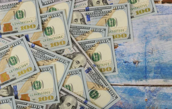 100 dolarové bankovky na modrém dřevěném pozadí. — Stock fotografie