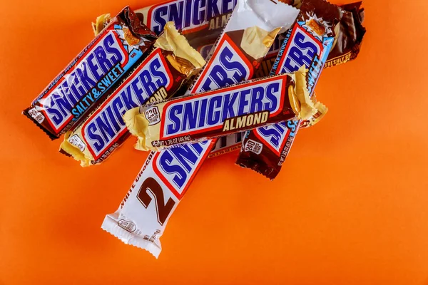 Snickers cioccolato bar acero burro di mandorle caramelle ang mandorla burro caramelle su sfondo arancione isolato — Foto Stock