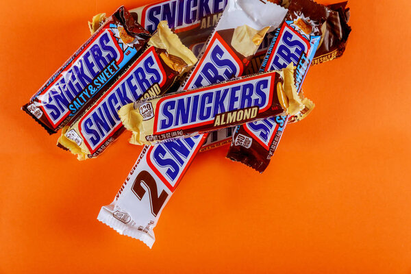 Snickers chocolate bar maple almond butter candy ang almond butter candy bar on orange isolated background